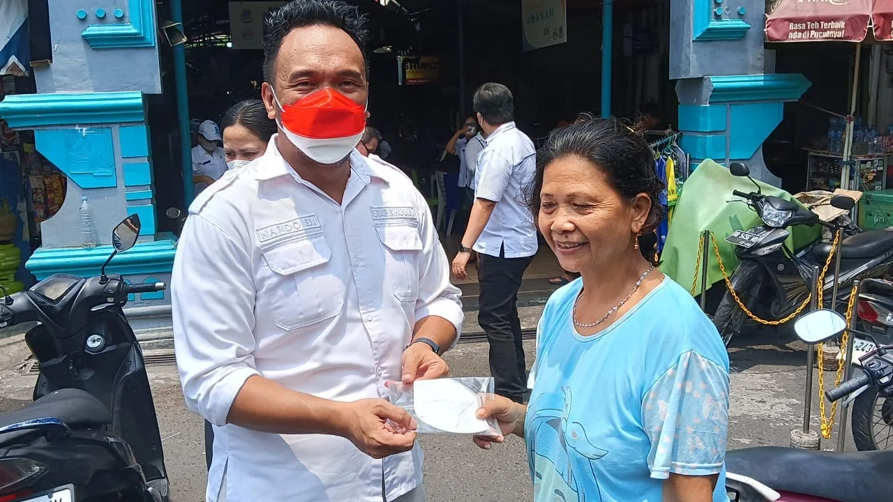 Stafsus Januardo Binilang saat membagikan masker kepada warga